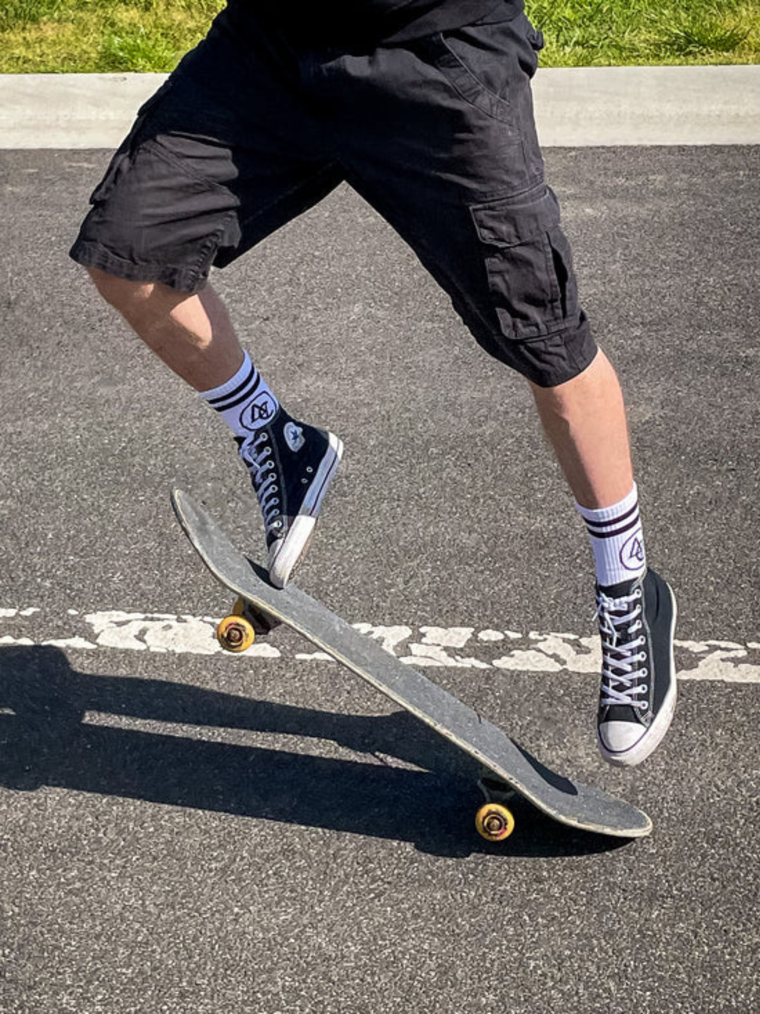 AC logo socks worn with high top converse sneakers, skate board